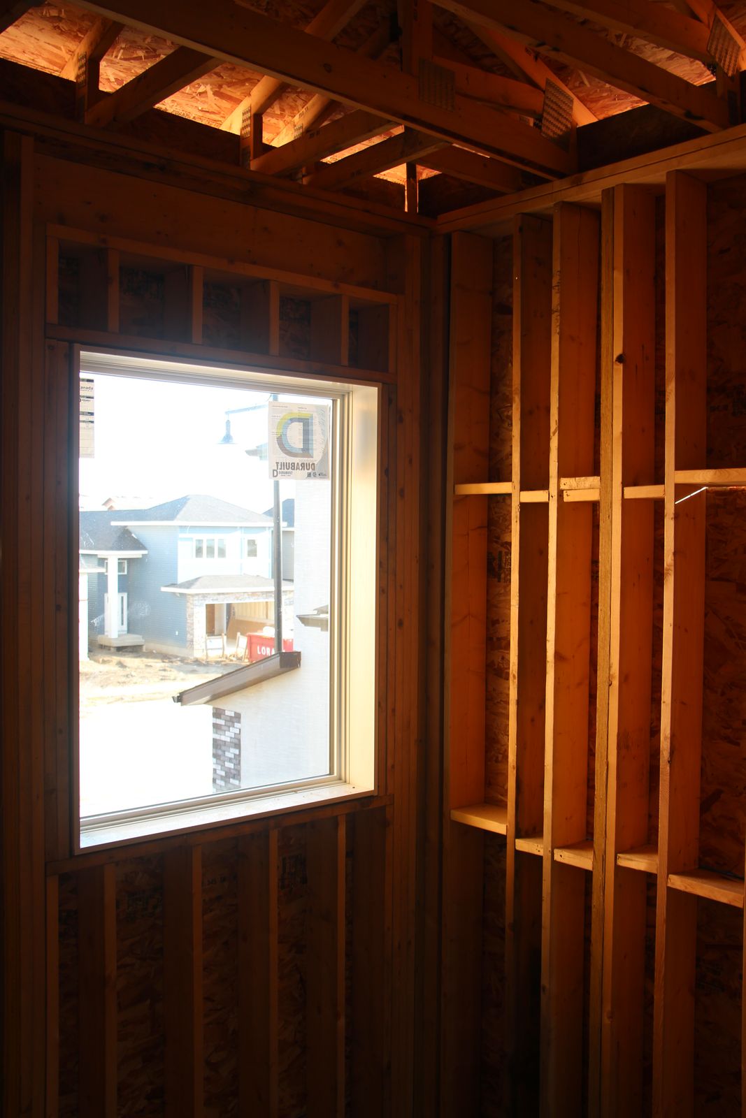 Framed second-storey window overlooking the neighbourhood mid-build